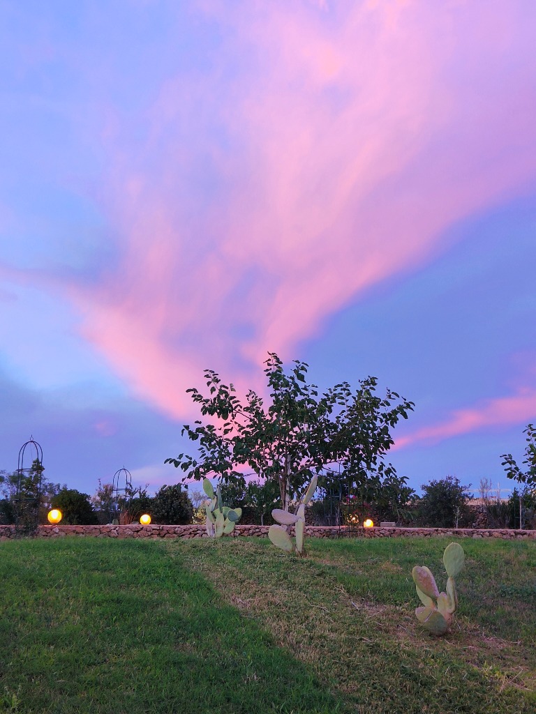 Scatto suggestivo del tramonto rosa e viola sulla masseria
